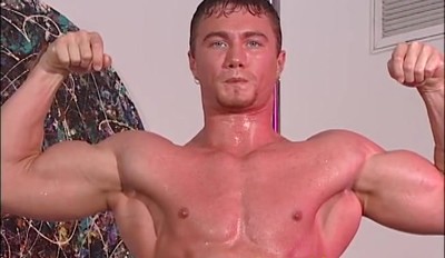 Wet Bodybuilder Poses with a Hard On on a Stripper Pole
